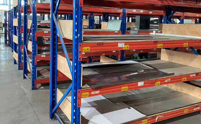 Blue industrial shelves in a warehouse, implying abundant stock of materials and components.