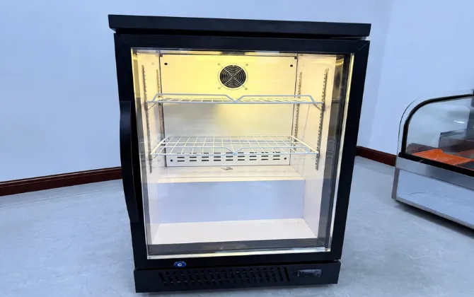 Internal view of a custom black glass door countertop display refrigerator featuring LED lighting, adjustable shelves, and forced-air cooling system.