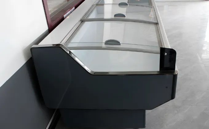 Finished island chiller unit undergoing final operational testing and glass sealing strip inspection before delivery.