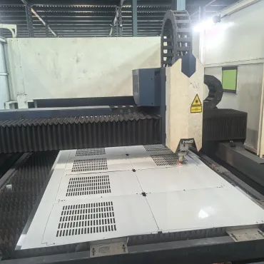 Laser cutting machine processing sheet metal panels with ventilation slots for refrigeration cabinets