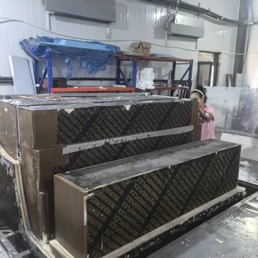 Worker beside a cabinet foaming mold in the refrigeration workshop
